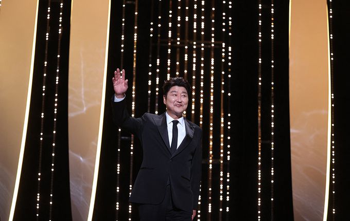 South Korean actor and member of the Jury of the Official Selection Song Kang-Ho waves as he arrives on stage during the closing ceremony of the 74th edition of the Cannes Film Festival in Cannes, southern France, on July 17, 2021. (Photo by Valery HACHE / AFP)