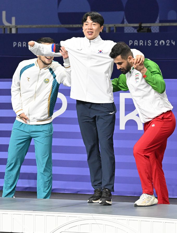 동메달을 획득한 주정훈이 프랑스 파리 그랑팔레에서 열린 2024 파리 패럴림픽 태권도 K44 남자 88kg급 시상식에서 다른 메달리스트들의 부축을 받으며 포디움에 오르고 있다. 사진=파리 공동취재단, 대한장애인체육회