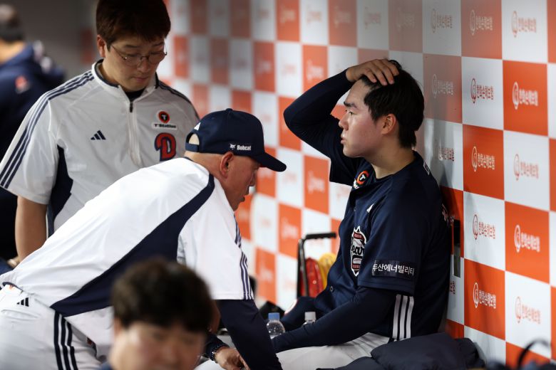 두산 최승용이 부상으로 교체된 이후 더그아웃에서 박정배 투수코치와 이야기를 나누고 있다. 사진=두산베어스 제공