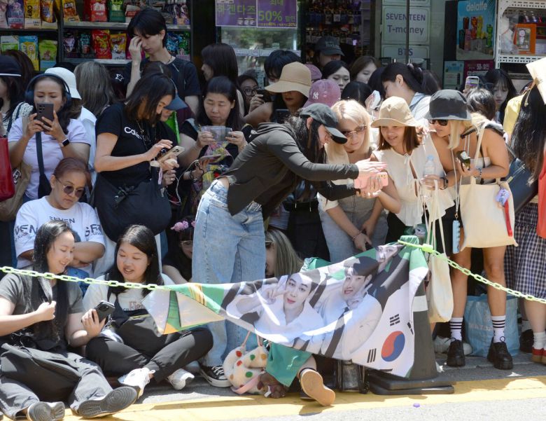 11일 방탄소년단(BTS)의 지민과 정국이 군 복무를 마치고 만기 전역했다. 지민과 정국의 전역을 축하하기 위해 서울 용산구 하이브 사옥인근에 글로벌 아미들이 모였다. 팬들이 기념사진을 찍고 있다. 김용학 기자