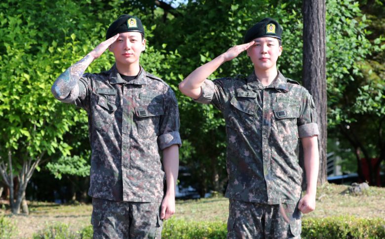 군 복무를 마친 방탄소년단 정국(왼쪽), 지민이 11일 오전 경기도 연천군의 한 부대 인근에서 전역인사를 하고 있다. 뉴시스 제공.