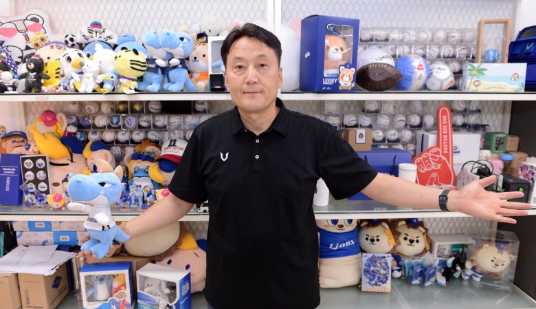 이정규 브이엑스 대표가 그동안 여러 프로팀과 국가대표팀의 굿즈 앞에서 포즈를 취하고 있다. 김두홍 기자