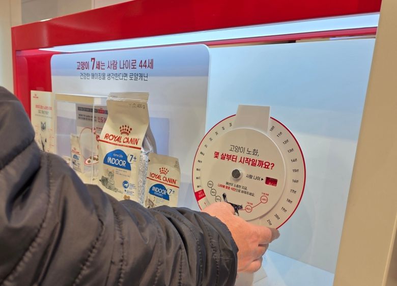 로얄캐닌 브랜드숍 방문객이 고양이의 사람 나이 알림 판넬을 통해 반려묘의 나이를 알아 보고 있다. 박재림 기자