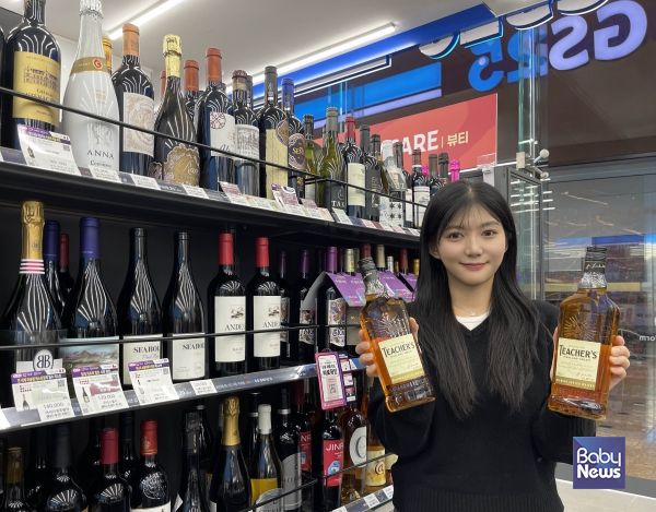 모델이 GS25에서 선보인 1만원대 가성비 위스키 '티처스' 상품을 들고 있다. ⓒGS25