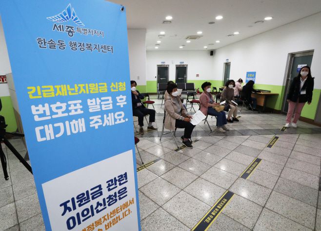 19일 오후 세종시 한솔동 행정복지센터에서 주민들이 긴급재난지원금을 신청하기 위해 거리 두기를 유지한 채 자리하고 있다./연합