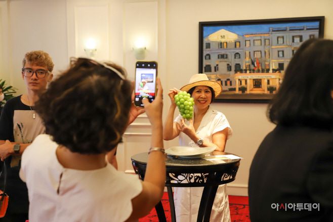 제1회 메트로폴 한국 미식주간 행사를 찾은 베트남 현지인들이 한국의 샤인머스켓 포도 ‘인증샷’을 찍고 있다. 이 날 행사에서는 한국의 소고기, 광어 등을 활용한 음식과 샤인머스켓이 큰 인기를 끌었다./사진=하노이 정리나 특파원