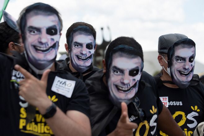 지난 10월 20일(현지시간) 브라질 수도 브라질리아에서 해골 모습으로 색칠된 자이르 보우소나루 대통령 가면을 쓴 시위대가 대통령의 신종 코로나바이러스 감염증(코로나19) 사태에 대한 부실 대응을 규탄하며 그의 퇴진을 촉구하고 있다. 브라질 상원의 코로나19 국정조사위원회는 이날 발표한 최종 보고서를 통해 보우소나루 대통령에 대한 기소 의견을 냈으며, 그에게 대통령 책임 회피, 예방적 보건위생 조치 무시 등 9개 혐의를 적용했다. /사진=EPA·연합