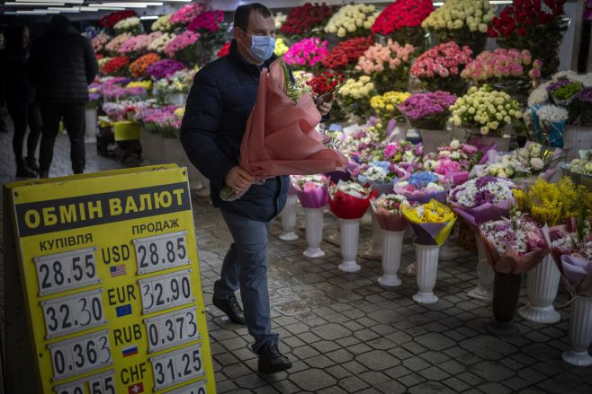 한 시민이 밸런타인데이인 14일(현지시간) 꽃다발을 들고 우크라이나 수도 키예프 시내를 걸어가고 있다./사진=키예프 AP=연합뉴스