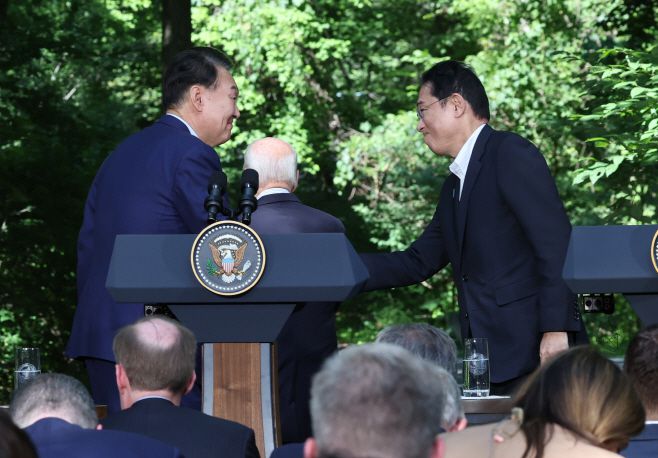 윤석열 대통령과 기시다 후미오 일본 총리가 18일(현지시간) 워싱턴DC 인근 미국 대통령 별장인 캠프 데이비드에서 한미일 정상 공동기자회견을 마친 뒤 악수하고 있다. /연합뉴스