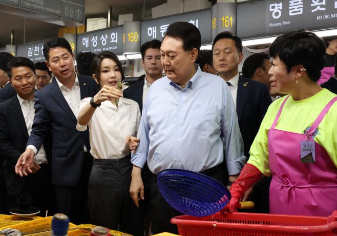윤석열 대통령과 함께 부산을 찾은 김건희 여사가 지난달 27일 부산 중구 자갈치시장에서 수산물을 살펴보다 새우를 직접 집어보고 있다./연합뉴스