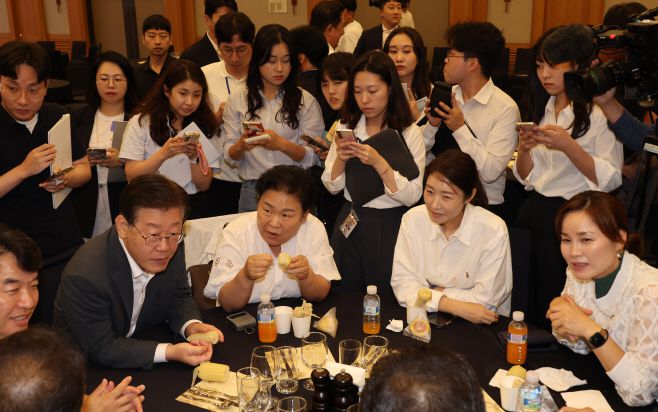 28일 강원 원주 오크밸리에서 열린 더불어민주당 국회의원 워크숍에서 이재명 대표가 의원들과 옥수수를 먹고 있다. /연합뉴스