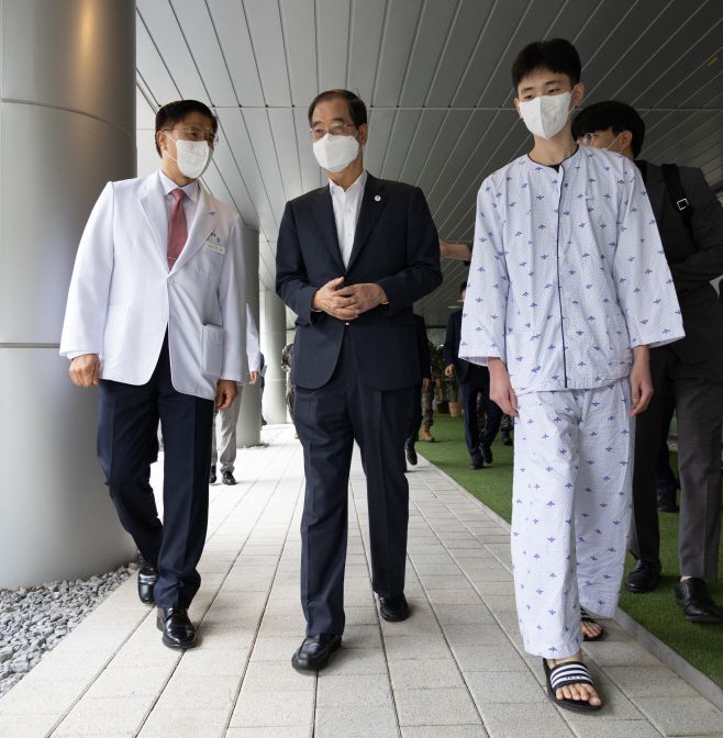 한덕수 국무총리가 추석 연휴 마지막 날인 3일 오후 경기도 성남 국군수도병원 내 국군외상센터를 찾아 지뢰 폭발로 다리를 심하게 다쳐 치료와 재활을 해왔던 표정호 병장과 병원 정원을 걷고 있다./연합뉴스