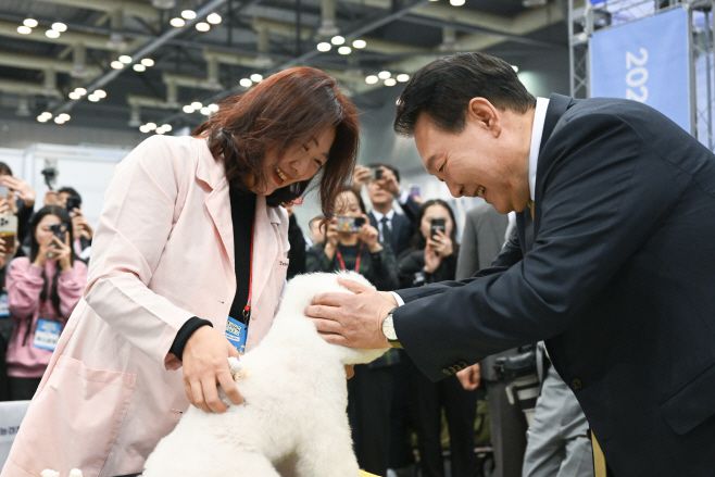 윤석열 대통령이 3일 경기도 고양시 킨텍스에서 열린 2023 대한민국 소상공인대회 개막식에서 펫 산업연합회 부스를 찾아 애견을 살펴보고 있다. /제공=대통령실