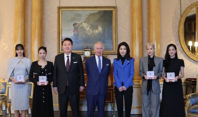 영국을 국빈 방문한 윤석열 대통령과 김건희 여사가 22일(현지시간) 런던 버킹엄궁에서 열린 문화 예술인 격려행사에서 찰스 3세 영국 국왕으로부터 대영제국훈장을 받은 블랙핑크 멤버들과 기념 촬영을 하고 있다. 왼쪽 부터 리사, 제니, 윤 대통령, 찰스 3세, 김 여사, 로제, 지수. /연합뉴스