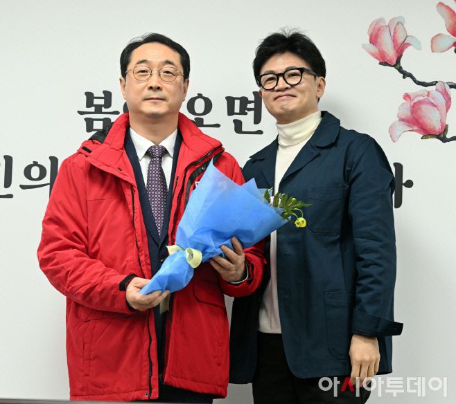 한동훈 국민의힘 비상대책위원장(오른쪽)이 지난달 29일 서울 여의도 당사에서 열린 국민인재 영입 환영식에서 김건 전 외교부 한반도평화교섭본부장에게 당점퍼를 입혀준 뒤 기념촬영을 하고 있다. /송의주 기자