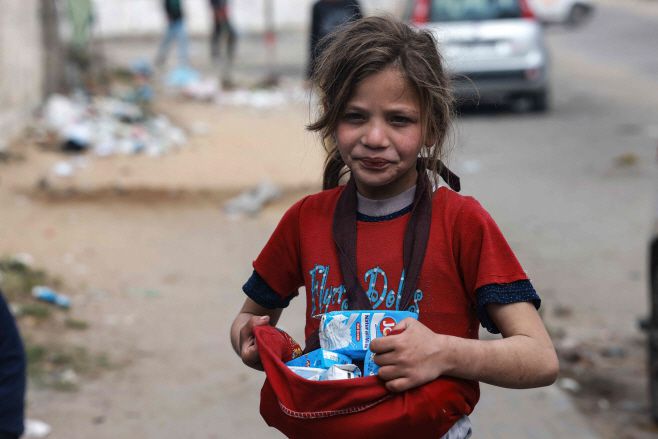 한 팔레스타인 어린이가 이슬람 금식성월인 라마단을 마무리하는 '이드 알피트르' 휴일을 앞둔 5일(현지시간) 가자지구 남부 라파의 거리 시장에서 우유를 팔고 있다./AFP·연합뉴스