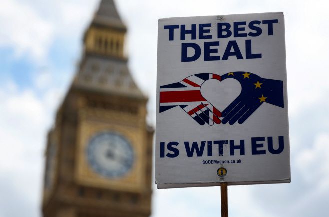 지난달 24일 영국 런던 국회의사당 앞에서 영국의 유럽연합(EU) 재가입을 촉구하는 내용의 플래카드가 세워져 있다. /EPA, 연합