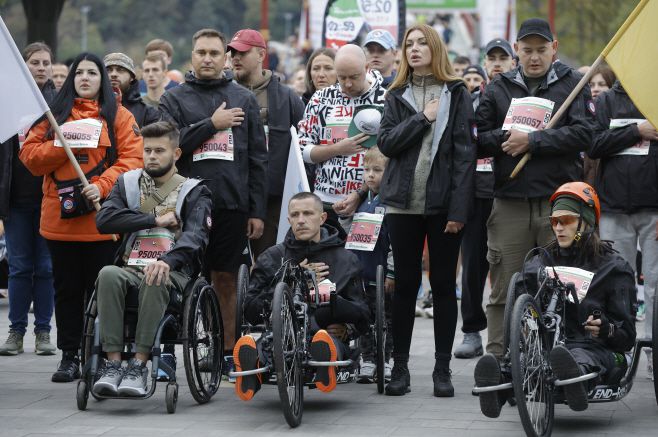러시아의 침략 전쟁에서 부상을 입은 우크라이나 군인들이 13일(현지시간) 우크라이나 키이우에서 열린 자선 '키이우 무적 마라톤'에 참가해 국민 의례를 하고 있다./EPA·연합뉴스