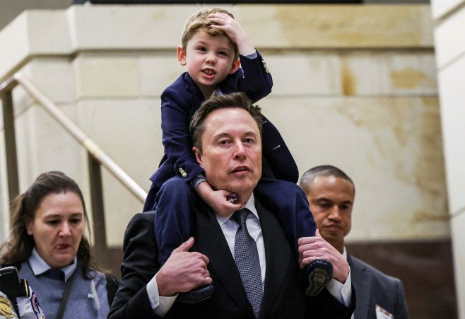 도널드 트럼프 미국 2기 행정부의 '정부효율부(DOGE)' 수장으로 지명된 일론 머스크 테슬라 최고경영자(CEO)가 5일(현지시간) 미국 워싱턴 D.C. 연방의회의사당을 방문하면서 아들을 목말 태우고 있다./로이터·연합뉴스