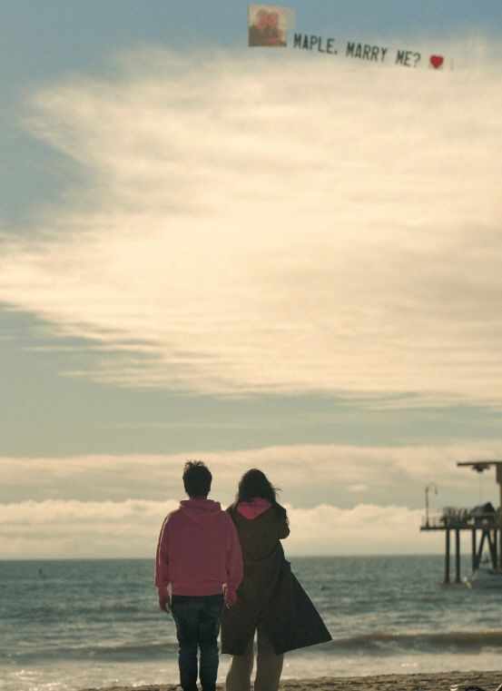 미 LA 산타모니카 해변에 서서 팡리선의 프로포즈 프래카드를 보고 있는 메이플 입. 둘은 14일 결혼했다./홍콩 싱다오르바오(星島日報).