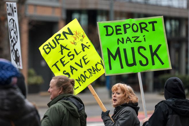15일(현지시간) 미국 워싱턴주 시애틀의 테슬라 전시장 앞에서 연방 기관 축소 등을 추진하고 있는 정부효율부(DOGE)를 이끌고 있는 일론 머스크에 항의하는 시위가 벌어지고 있다./AFP 연합뉴스