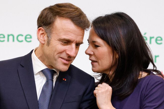 에마뉘엘 마크롱 프랑스 대통령(왼쪽)과 아날레나 베어보크 독일 외무부 장관이 13일(현지시간) 프랑스 파리의 파리 각료회의 센터에서 열린 시리아 문제 국제회의에서 단체 기념사진을 찍으면서 대화를 나누고 있다./AFP·연합뉴스