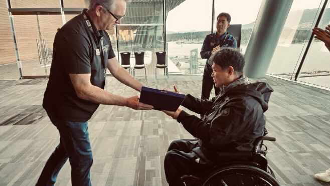 2025 캐나다 인빅터스 게임 한국 선수단장 한태호 대한민국상이군경회 복지국장이 14일 밴쿠버 컨벤션센터에서 도미니크 리드 인빅터스 게임 재단(IGF) 최고경영자(CEO)에게 유을상 대한민국상이군경회 회장 명의의 감사패를 전달하고 있다./공동취재단