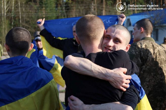 우크라이나 전쟁 포로들이 19일(현지시간) 우크라이나의 미공개 장소에서 러시아 전쟁 포로와의 교환이 이뤄진 뒤 기뻐하고 있다./로이터·연합