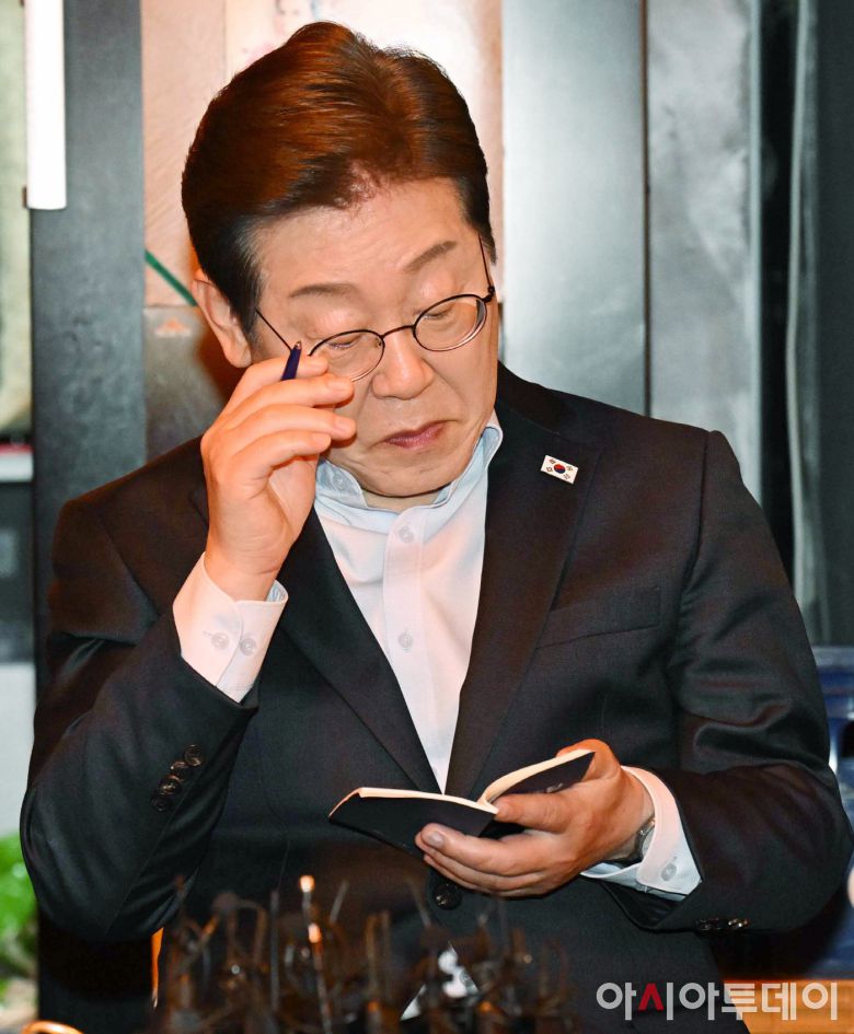 이재명 더불어민주당 대선 후보가 1일 서울 종로구의 한 음식점에서 열린 비전형 노동자 간담회에 참석해 수첩을 살펴보고 있다.대법원 전원합의체는 이날 이 후보에게 무죄를 선고한 원심판결을 파기하고 사건을 서울고법으로 돌려보냈다.조태형 기자 2025.05.01