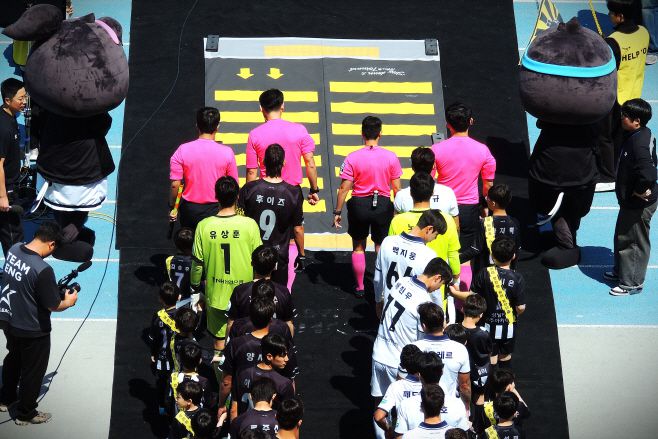 성남FC와 서울 이랜드 선수단이 '슬로우 다운 & 무브 포워드' 어린이 교통안전 캠페인의 일환으로 형상화된 스쿨존 횡단보도를 지나며 입장하고 있다./ 전형찬 선임기자