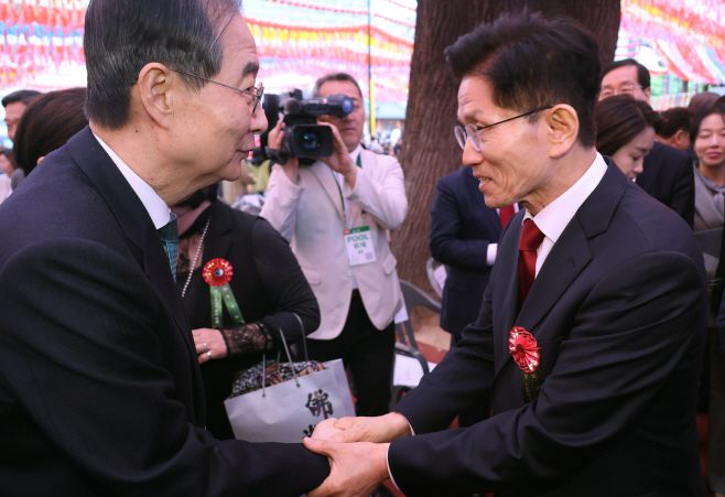 김문수 국민의힘 대선 후보(오른쪽)와 무소속 한덕수 대선 예비후보가 5일 서울 종로구 조계사에서 열린 불기 2569년 부처님오신날 봉축법요식을 마친 뒤 악수하고 있다. /연합