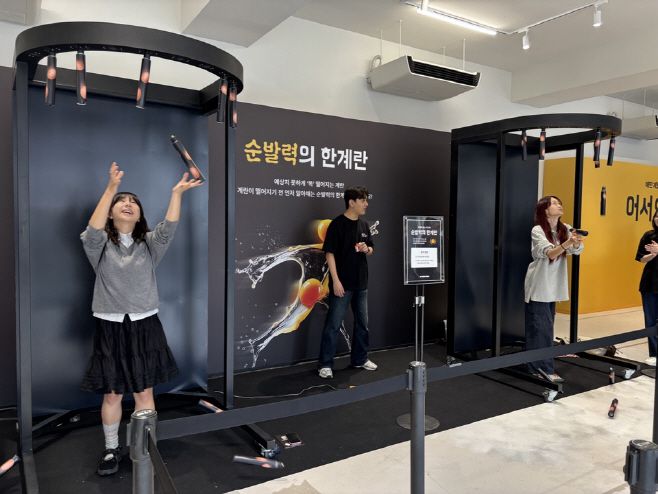 9일 서울 성동구 성수동 'XYZ Seoul'에서 열린 배민 '계란프라이데이' 팝업스토어의 게임존 중 하나인 '순발력의 한계란'에서 방문객들이 떨어지는 막대 봉을 잡는 게임을 하고 있다./박진숙 기자 act@asiatoday.co.kr
