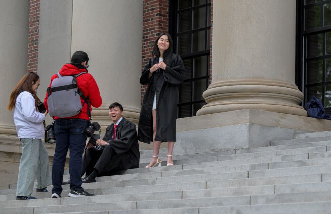 중국계로 보이는 미국 하버드대 졸업생들이 23일(현지시간) 매사추세츠주 케임브리지에 있는 하버드대에서 기념사진을 찍고 있다./로이터·연합