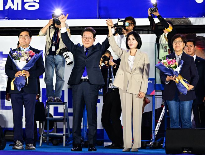 이재명 제21대 대통령이 부인 김혜경 여사가 함께 4일 서울 여의도 국회 인근에서 더불어민주당 주최로 열린 국민개표방송 행사에 참석해 시민들을 향해 인사하고 있다./공동취재단