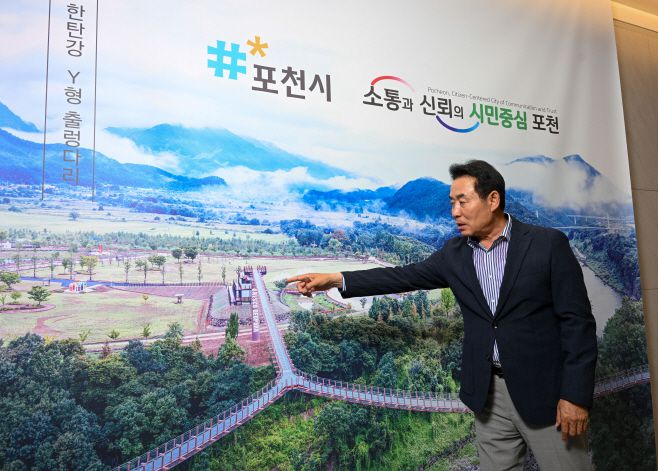 백영현 포천시장이 5일 시장 집무실에서 진행된 아시아투데이와 인터뷰가 끝난 뒤 집무실 한쪽 벽에 걸려  있는 Y형 출렁다리 현수막을 가리키고 있다./정재훈기자