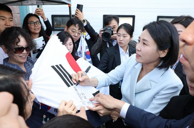 G7 정상회의에 참석하는 이재명 대통령과 함께 캐나다를 방문한 김혜경 여사가 17일(현지시간) 캘거리 한인회관에서 환영나온 주민들의 요청에 태극기에 서명하고 있다./연합뉴스