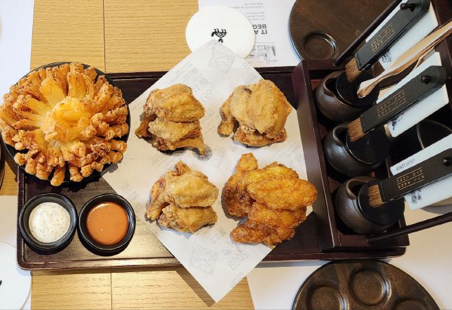 왼쪽에 있는 튀김은 구미산 양파를 활용했다. 교촌치킨은 1호점에서만 만날 수 있는 다양한 특화 메뉴를 선보이겠다고 밝혔다./ 차세영 기자