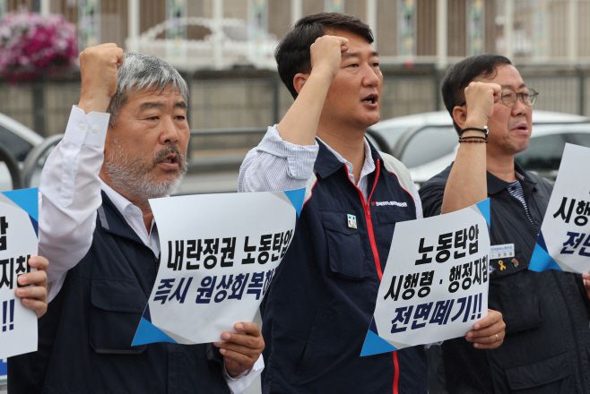 6월 25일 서울 용산구 대통령실 앞에서 열린 '위법한 시행령·행정지침 원상회복 요구 양대노총 기자회견'에서 양경수 민주노총 위원장(가운데)과 김동명 한국노총 위원장(왼쪽) 등의 참가자들이 구호를 외치고 있다. /연합뉴스