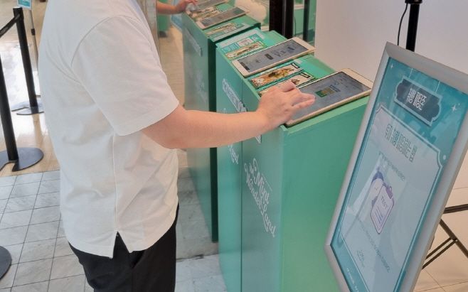 투자취향 테스트 부스에는 두 대의 태블릿 PC가 비치돼있다. 테스트 화면이 띄워져 있어 바로 시작할 수 있다. 테스트가 끝난 후 옆에서 포토카드 제작을 위한 사진을 찍을 수 있다./이종근 인턴기자