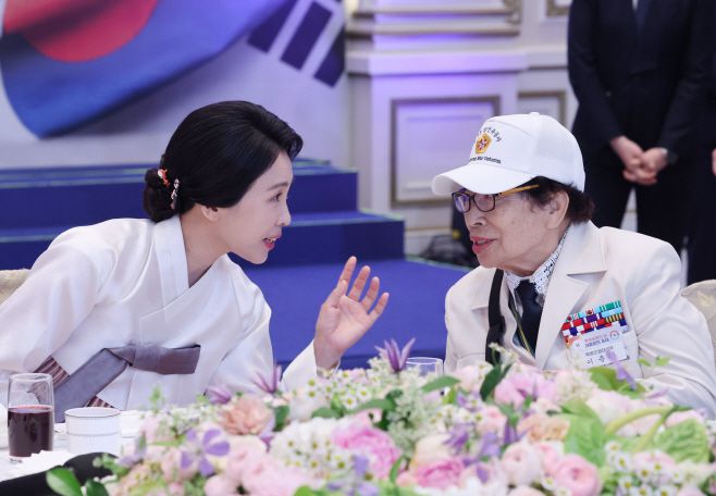 이재명 대통령과 김혜경 여사가 27일 청와대 영빈관에서 열린 '호국 보훈의 달, 대통령의 초대' 행사에서 6·25전쟁에 참전해 유격대원으로 활약했던 여성 참전유공자 이춘자 참전용사와 대화하고 있다. /연합뉴스