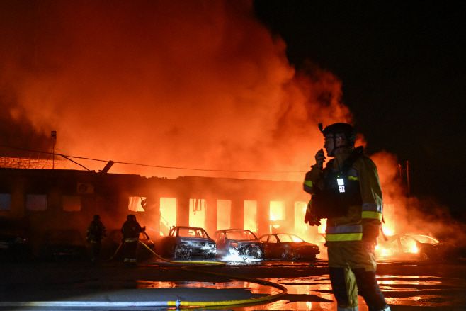 지난달 18일 러시아의 우크라이나 공격 속에서 자포리자에 위치한 한 민간 기업이 드론 공격을 받았다. 사진은 현장에서 소방관들이 진화 작업을 벌이고 있는 모습. /로이터·연합