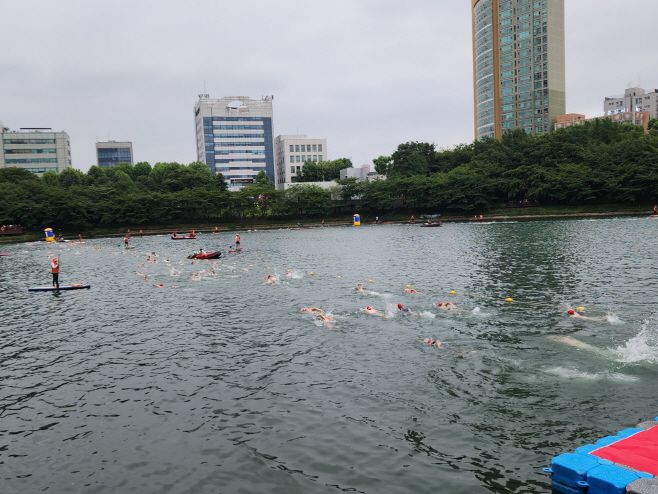 각자 다른 색의 수영모를 쓴 참가자들이 석촌호수 동호를 수영하고 있다. 총 2바퀴(1.5km)를 돌아야 한다./ 차세영 기자