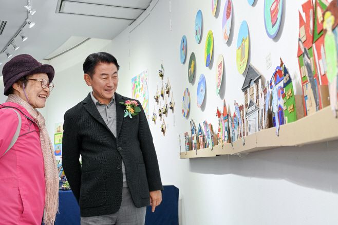 김동근 의정부시장(오른쪽)이 지난해 10월 25일 회룡시니어전시회 기념식에서 한 어르신과 함께 작품을  자세히 들여다보고 있다./의정부시