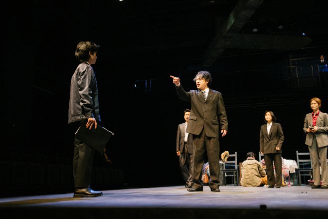 연극 '관저의 100시간' 공연 장면. 재난 속에서도 결정을 유보하는 정치인과 관료들의 무기력한 회의가 무대 위에 펼쳐진다. 무대 위 고발과 침묵이 교차하는 이 장면은, 연극의 윤리적 시선을 그대로 드러낸다. / 사진 네버엔딩플레이