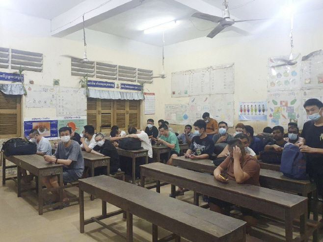 18일 캄보디아 국영 언론이 공개한 사진. 당국에 체포된 온라인 사기 조직의 용의자들이 캄보디아 프놈펜 외곽의 교실에 앉아 있다/AP 연합뉴스