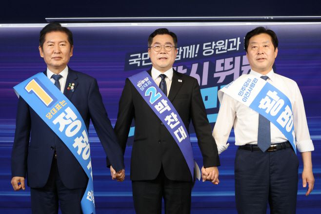 더불어민주당 정청래·박찬대(가운데) 당대표 후보, 황명선 최고위원 후보(오른쪽)가 20일 서울 여의도 당사에서 열린 8·2 전당대회 순회 경선 영남권 합동연설회에서 손을 잡고 인사하고 있다. /연합