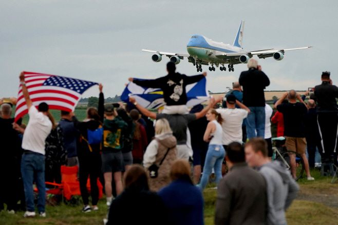 스코틀랜드 시민들이 25일(현지시간) 스코틀랜드 글래스고 프레스윅 공항에서 도널드 트럼프 미국 대통령이 탑승한 전용기 '에어포스원'이 착륙하는 모습을 지켜보고 있다./AP·연합
