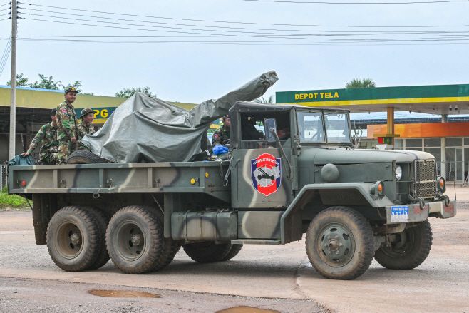 캄보디아 군인들이 26일(현지시간) 캄보디아 오다르 메안체이 지방에서 대공포를 장착한 군용 트럭 위에 서 있다./AFP·연합