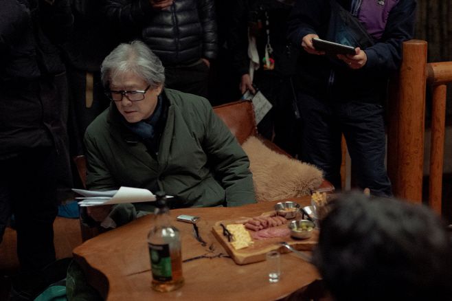 박찬욱 감독이 '어쩔수가없디' 촬영장에서 현장 대분을 확인하고 있다./제공=CJ ENM