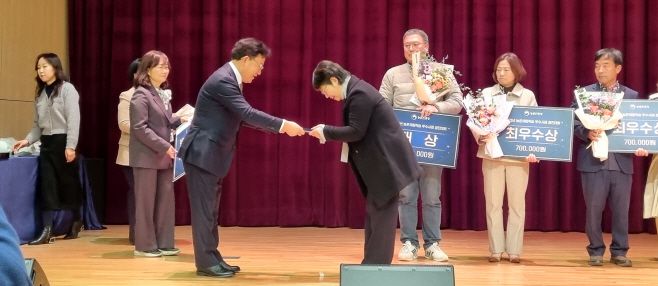 김정아 해피타임농원 대표(오른쪽)가 지난달 28일 농촌진흥청 농업과학도서관 오디토리움에서 열린 2025년 농촌체험학습 우수사례 경진대회에서 우수상을 수상하고 있다. /군위군청